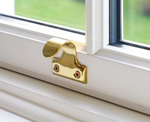 Gold window handle on white Everest conservatory window