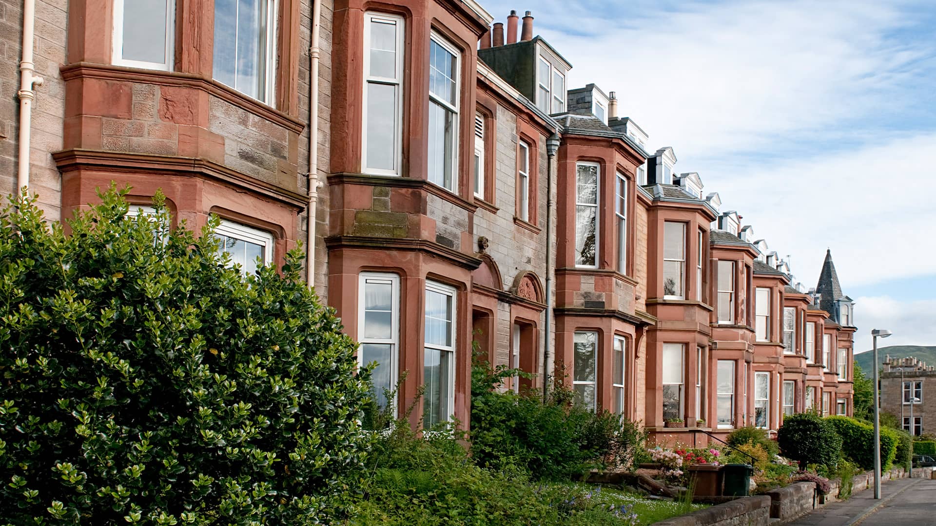 Row of terraced houses with red sandstone and white windows