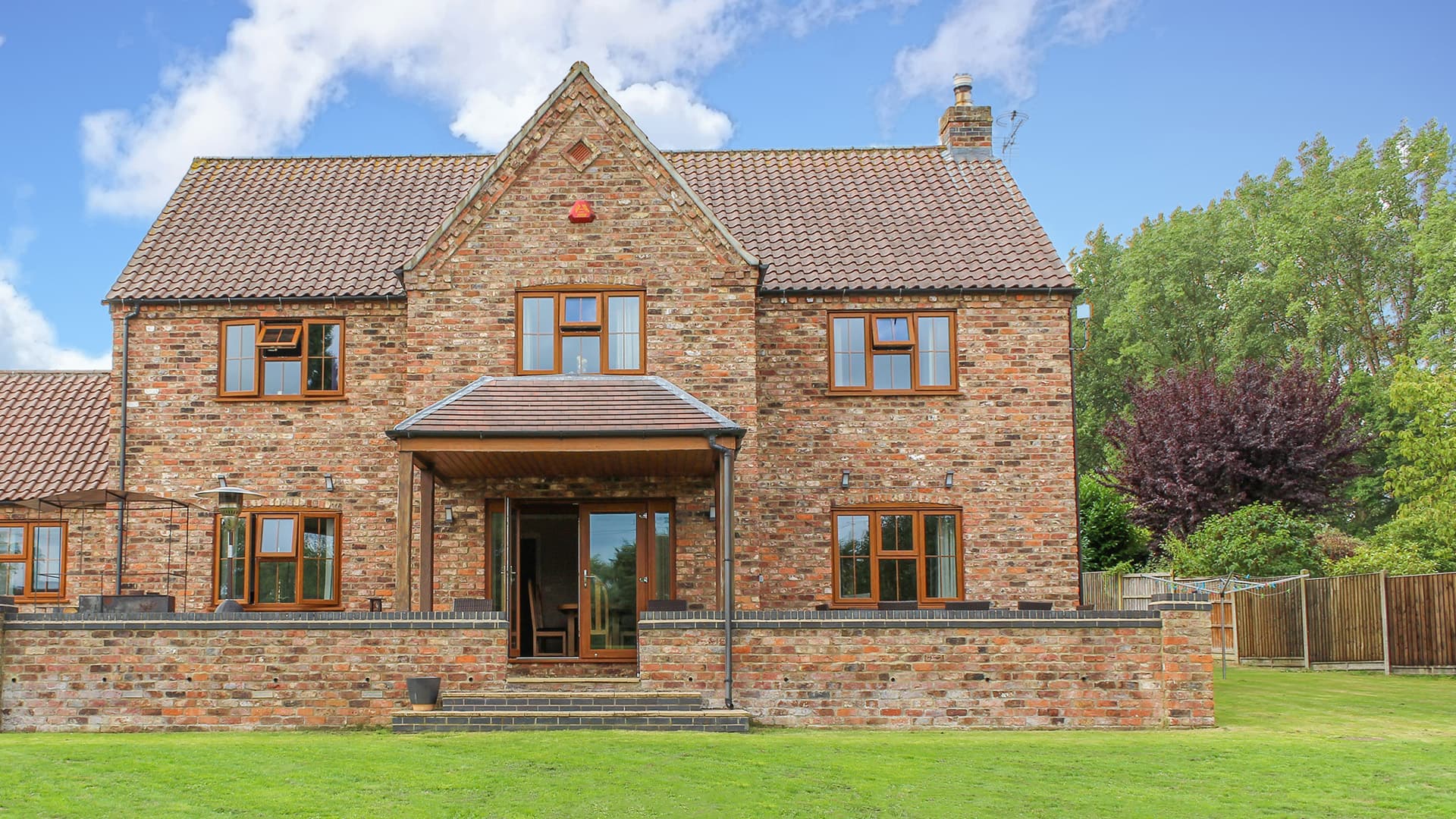 Brick house with brown timber windows and a veranda