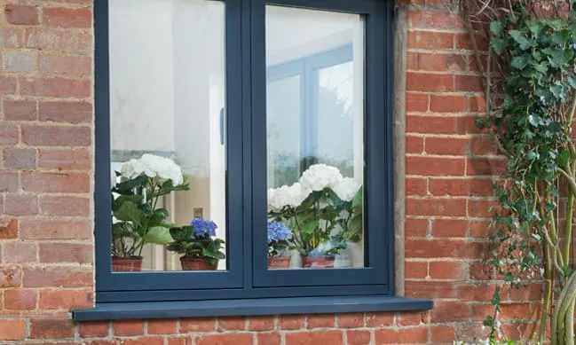 Dark gray Everest window on brick wall