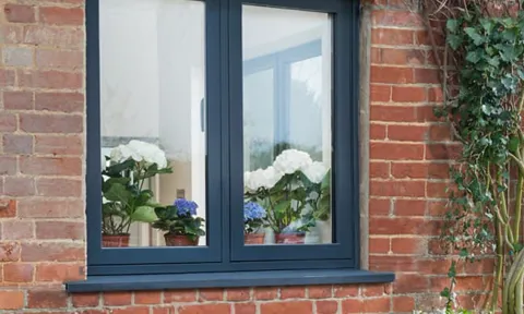 Dark gray Everest window on brick wall