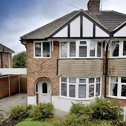 Brick house with white windows and arched doorway
