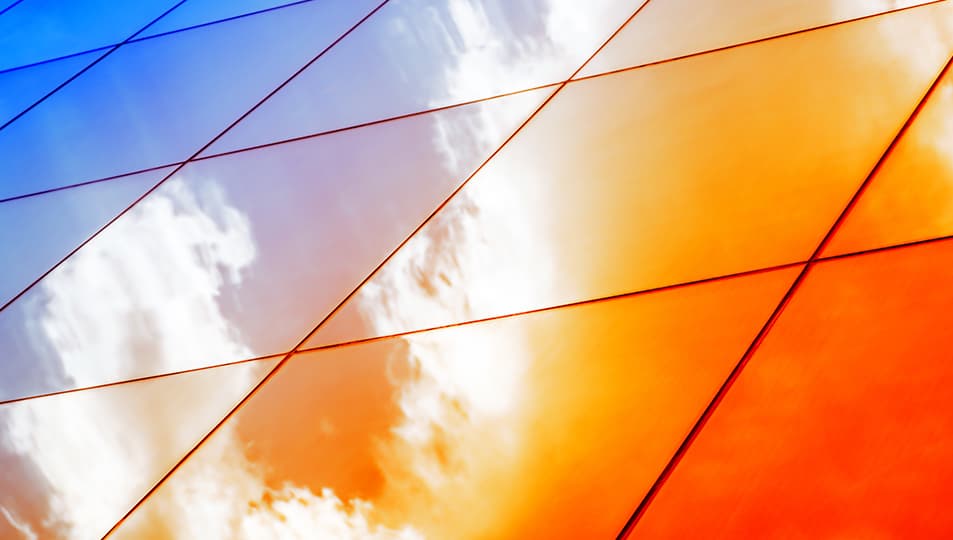 Orange and blue building facade with clouds reflected
