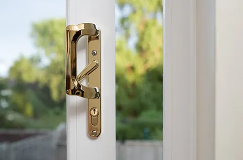 Gold door handle on white Everest conservatory