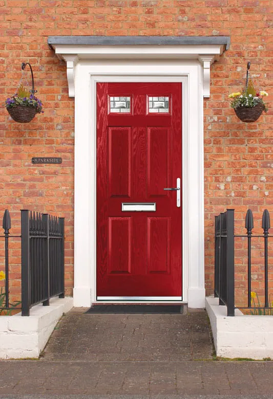 Red front door with white trim on brick house