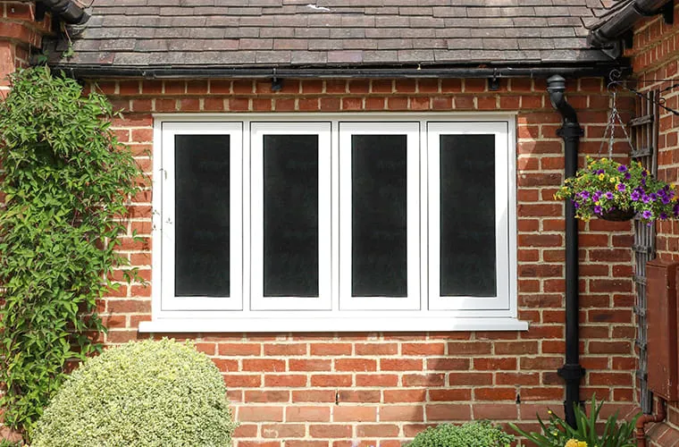 White window with dark glass on brick wall