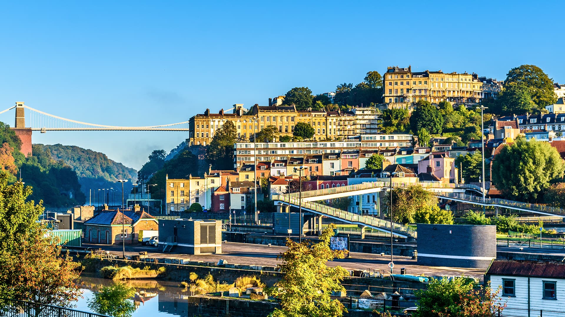 Cityscape with colorful buildings and a suspension bridge
