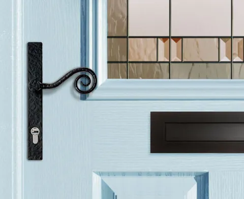 Black door handle with decorative scroll on light blue door