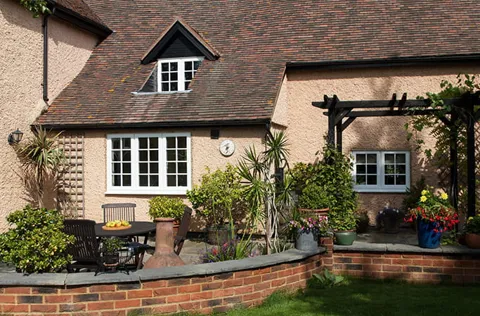 Cream house exterior with white windows and garden patio
