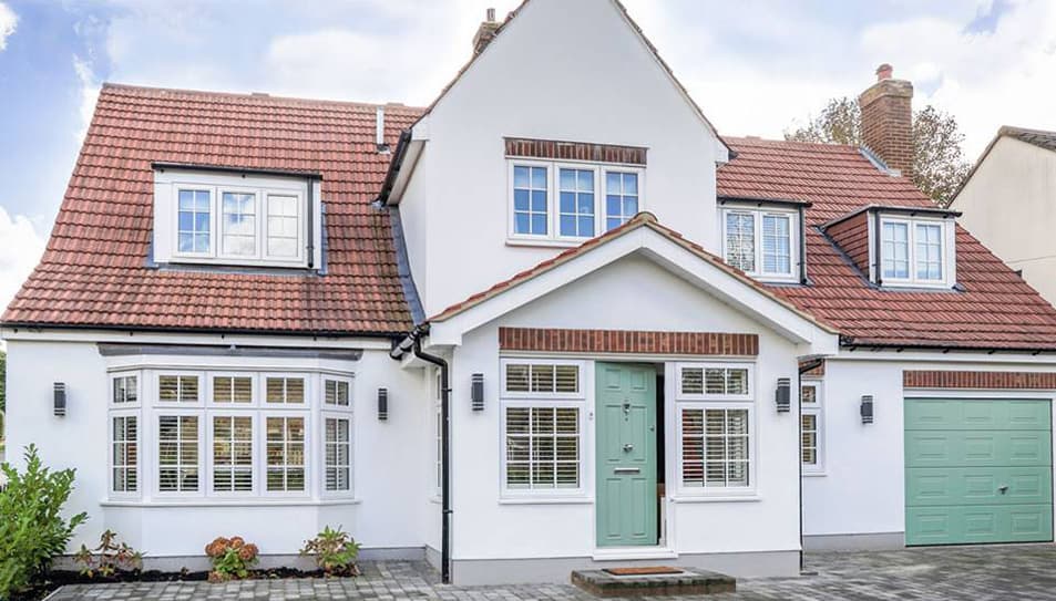 White house with terracotta roof and sage green door