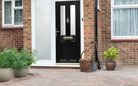 Black door with white trim on a brick house