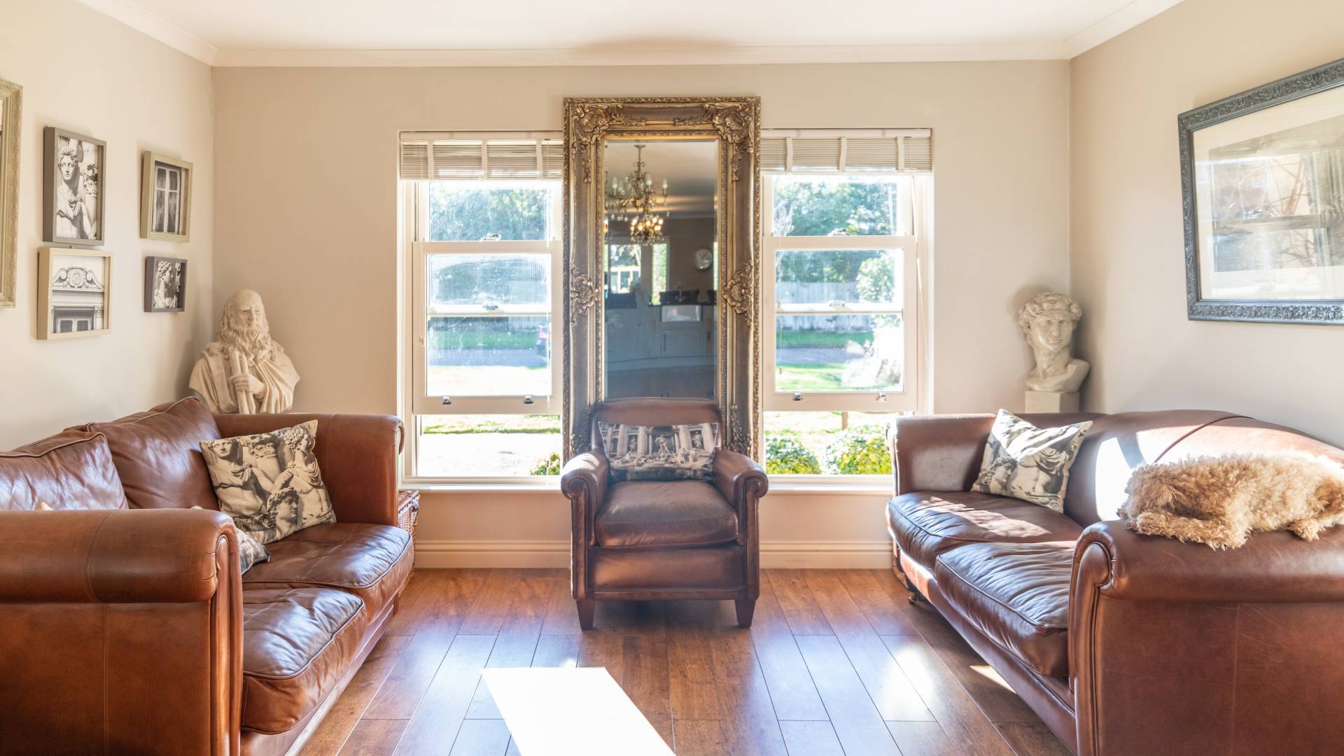 Brown leather sofas and armchair in a light room