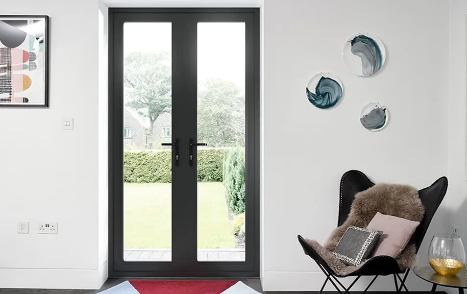Dark gray double doors with glass panels leading to a garden