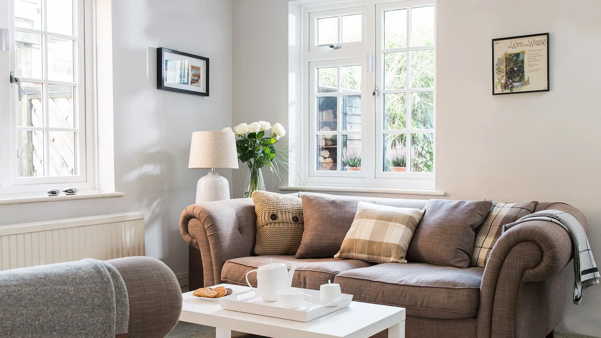 Brown sofa with white cushions and throws