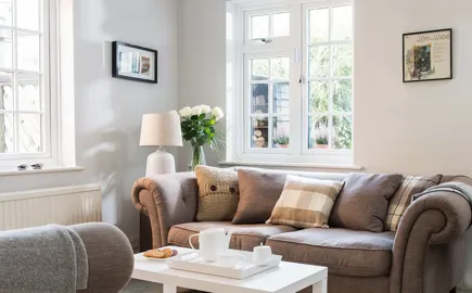 Brown sofa with white cushions and throws