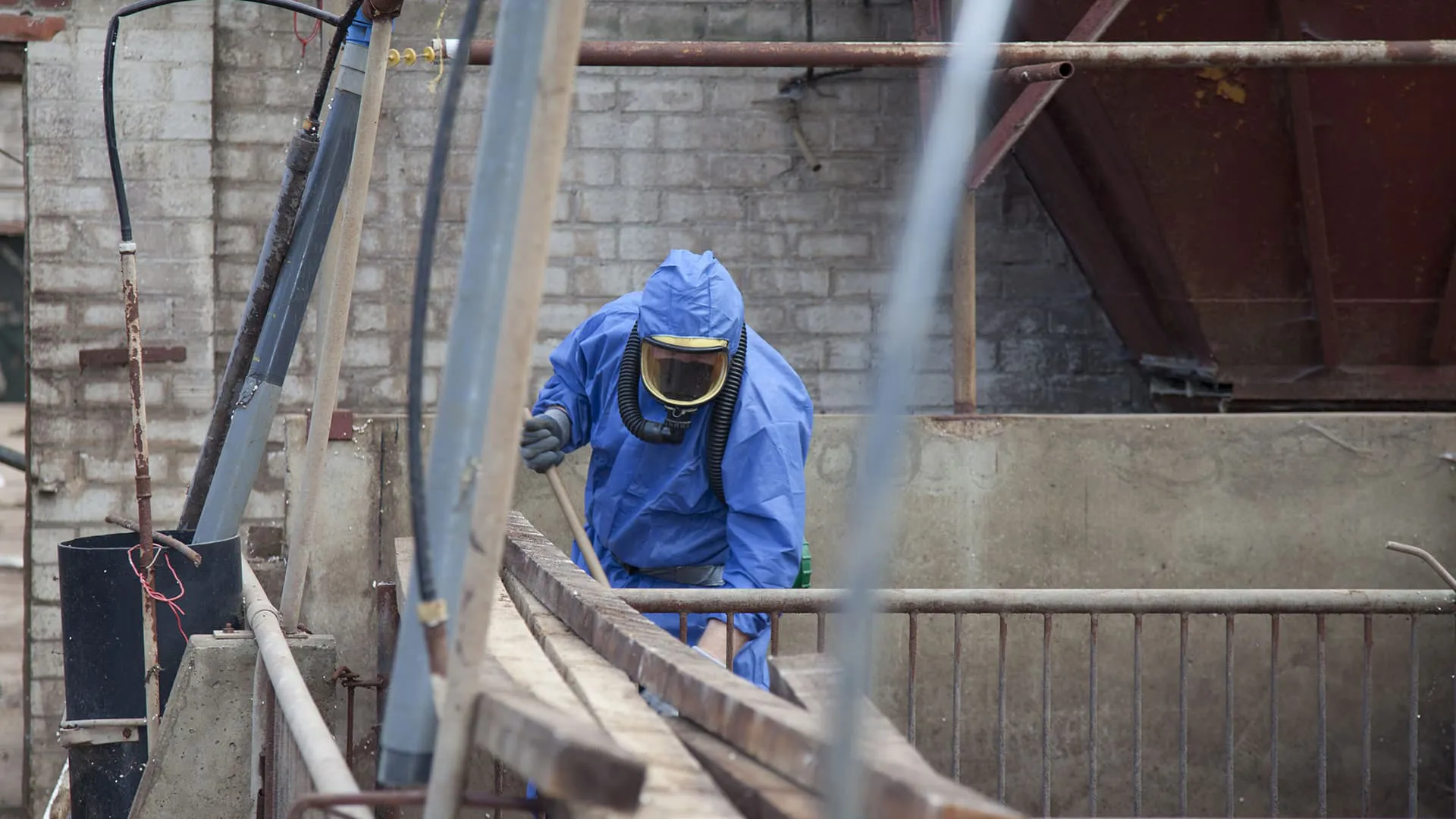 Person in blue protective suit working outdoors