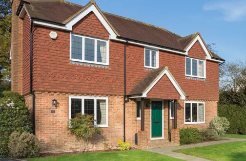 Brick house with terracotta roof and white windows
