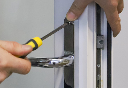 Person using screwdriver to fix Everest conservatory door handle