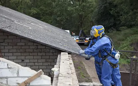 Person in protective suit removing roof panel