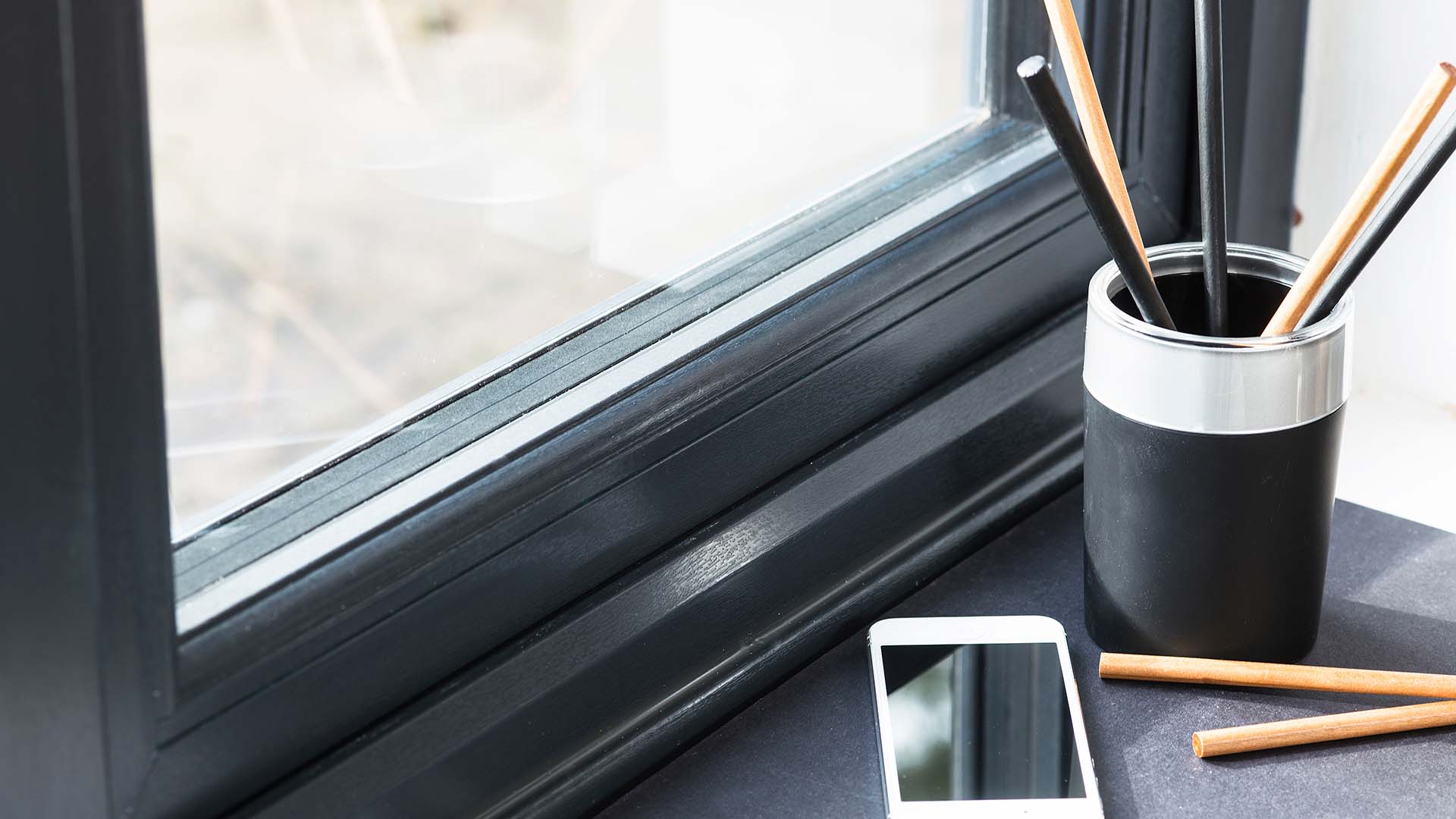 Black pencil holder with light coloured pencils