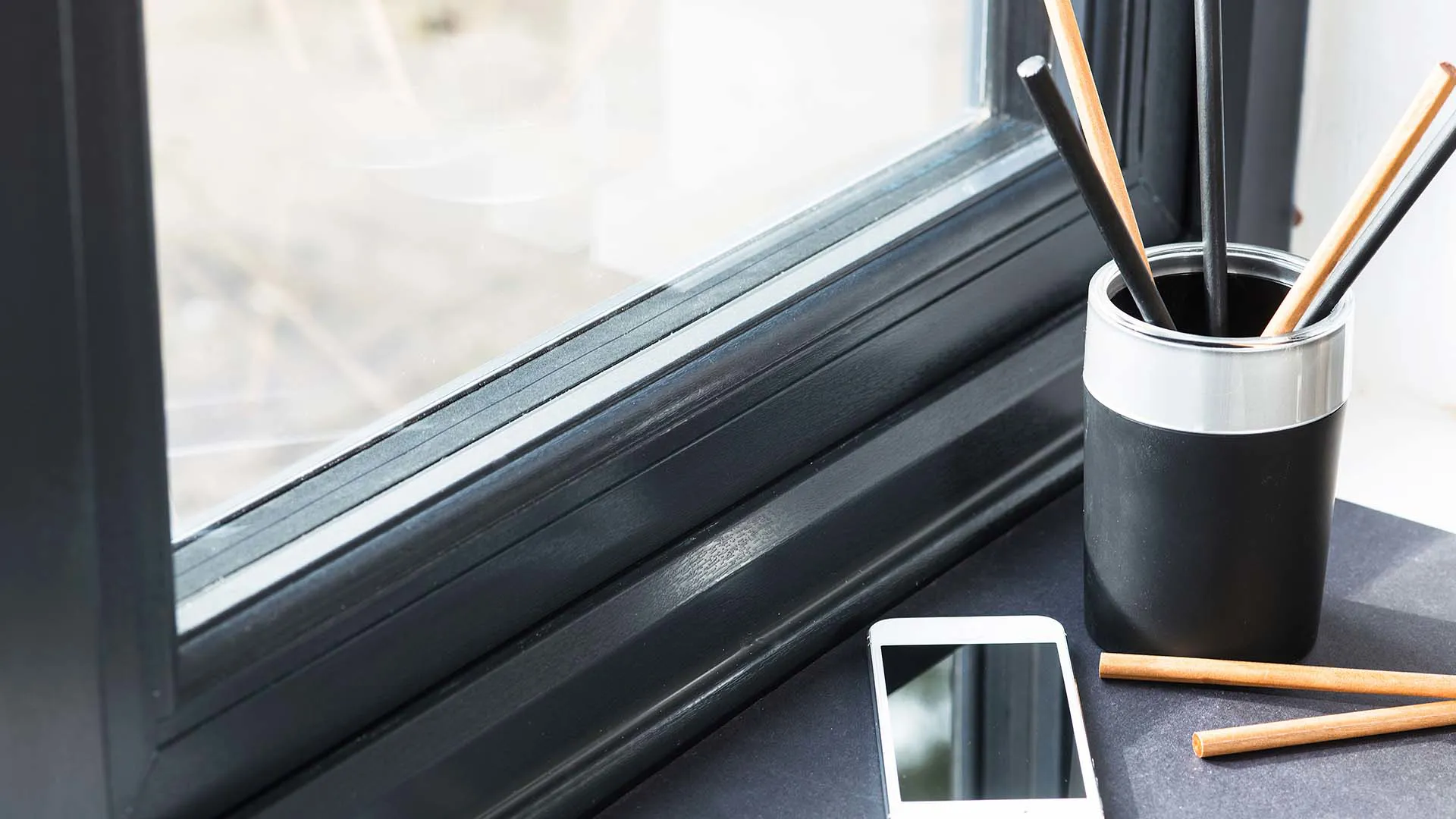 Black pencil holder with light coloured pencils