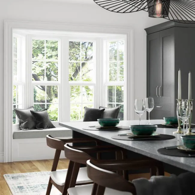 White bay window with grey velvet cushions in a kitchen
