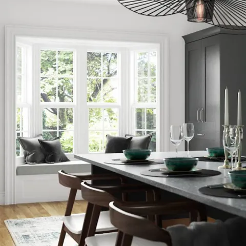 White bay window with grey velvet cushions in a kitchen