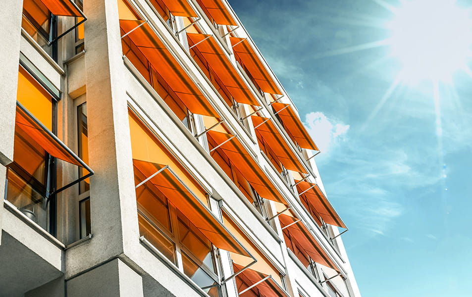 Orange window awnings on a light gray building