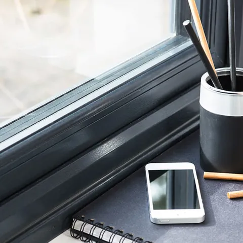 Dark grey Everest window frame with white phone and stationary
