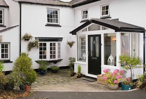 White house with black Everest conservatory and door