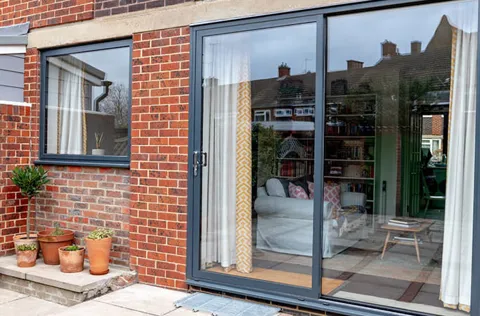 Grey Everest conservatory sliding doors with brick wall