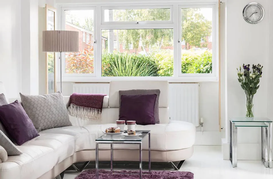 White leather sofa with purple cushions and coffee table