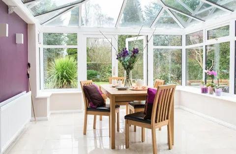 Everest conservatory with white frames and purple accents