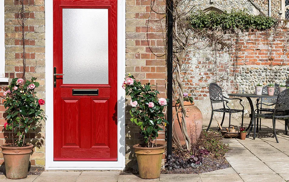 Red door with white trim and pink flowers