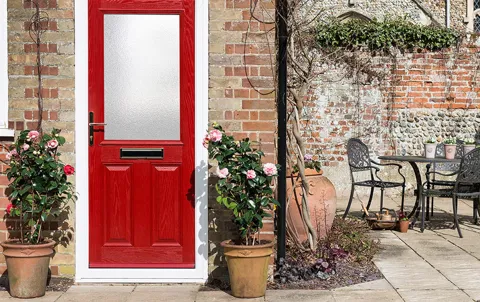 Red door with white trim and pink flowers