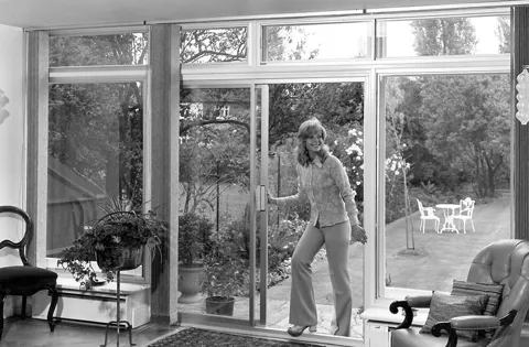 Woman opening Everest conservatory sliding glass doors