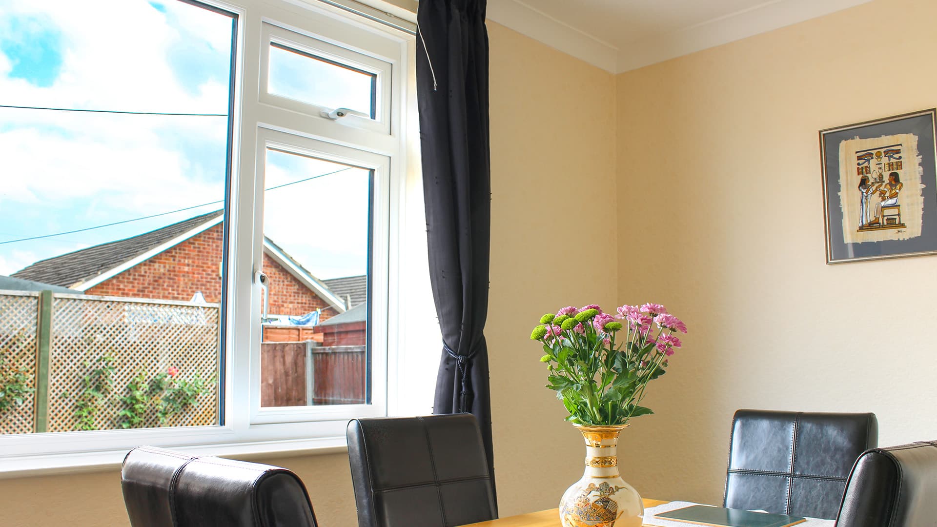 White window with black curtains in a dining room