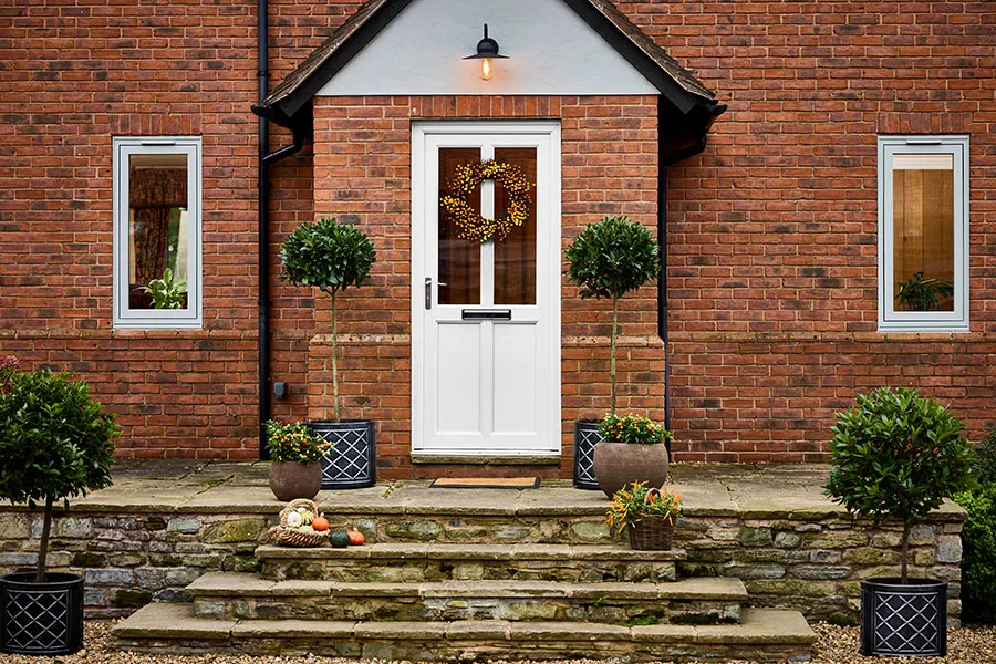 uPVC white front door with 2 glazing panels dressed with an autumn wreath