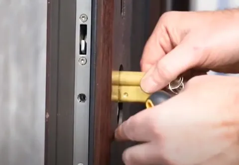 Hands inserting key into door lock