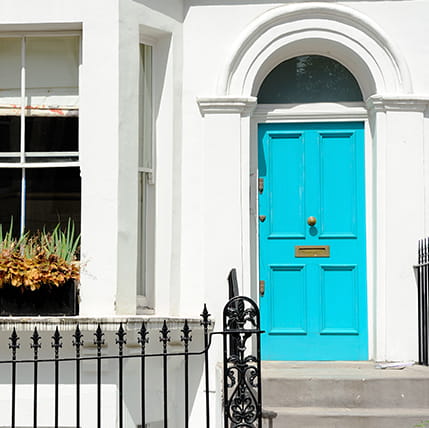 Bright teal door on white house exterior