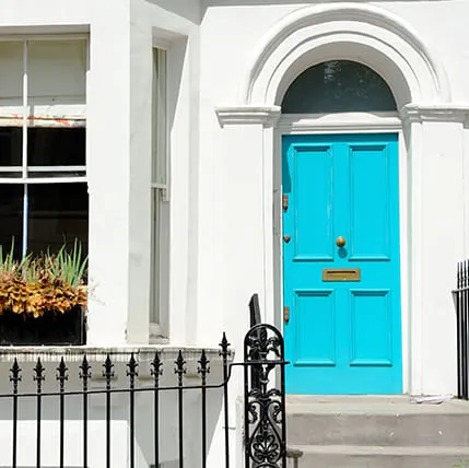 Bright teal door on white house exterior