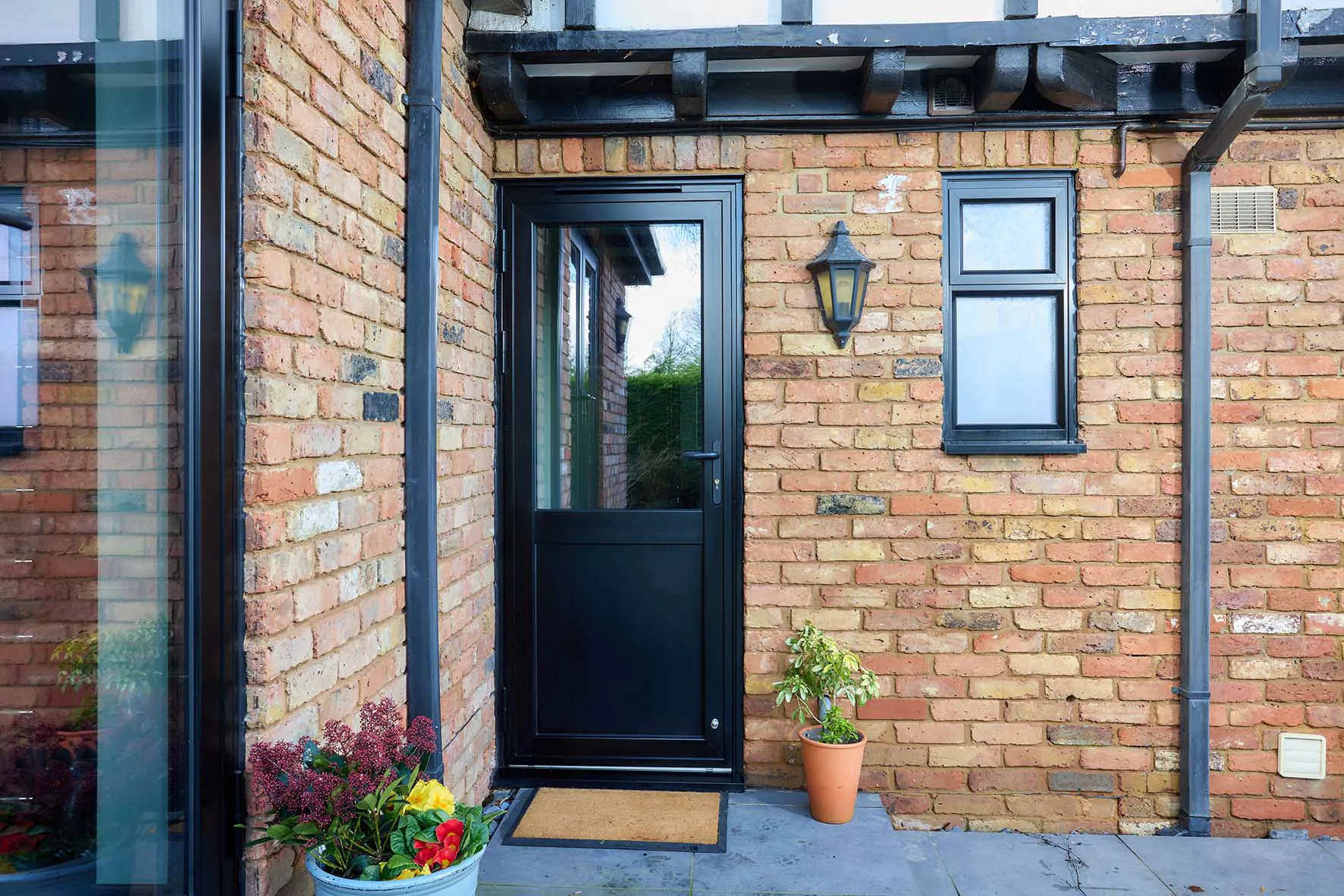 An aluminium black back door with a single glazed unit over a flat panel