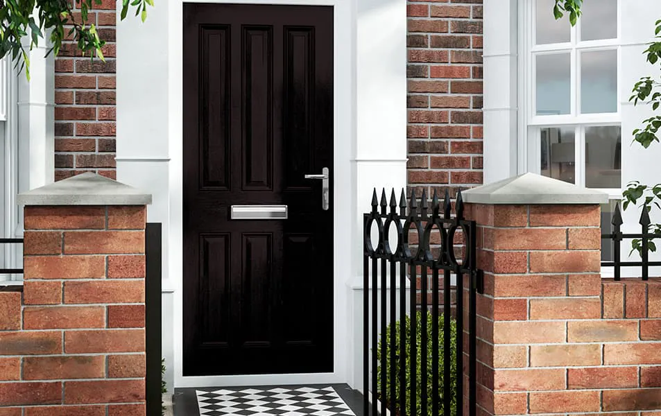 Dark brown door with brick walls and black metal railings