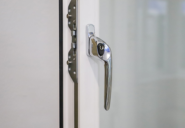 Chrome window handle on white Everest conservatory