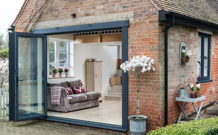 Everest conservatory with grey bi-fold doors and brick walls