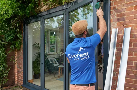 Everest conservatory installation by worker in blue shirt