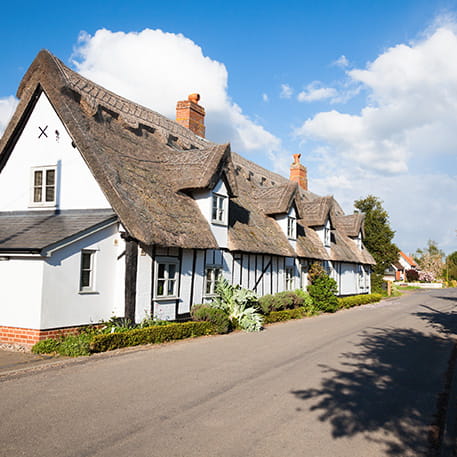 Charming row of thatched roof cottages on a sunny day